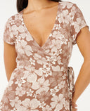 Woman wearing a flora WRAP dress on a white background