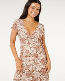 Woman wearing a flora WRAP dress on a white background