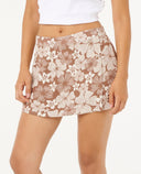 Woman wearing a white crop top and floral skort on a white background