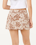 Woman wearing a white crop top and floral skort on a white background