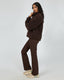 Model wearing All About Eve Amara Quarter Zip Teddy in brown with matching pants, showing cozy winter activewear style