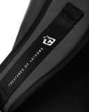 Close-up of a black strap with 'Creatures of Leisure' branding on a dark background