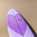 Purple surfboard with a logo on a sandy background